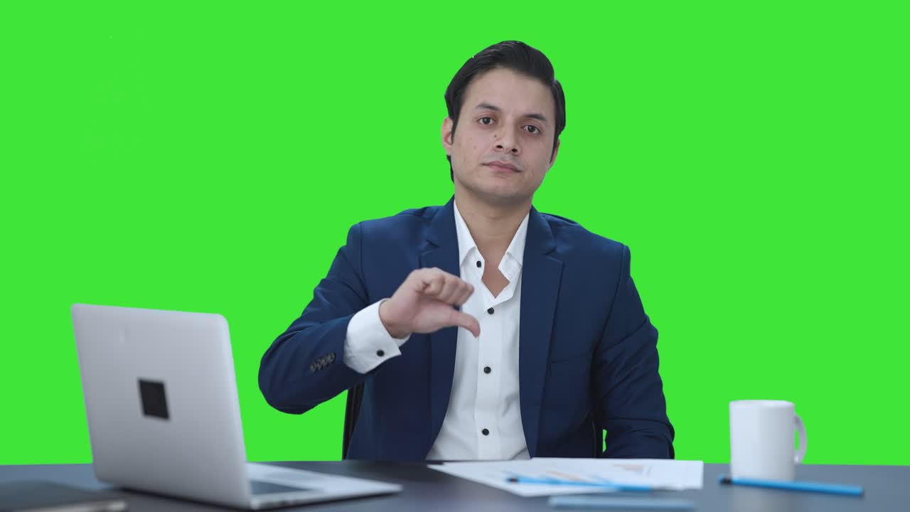 Disappointed Indian businessman showing thumbs down Green screen