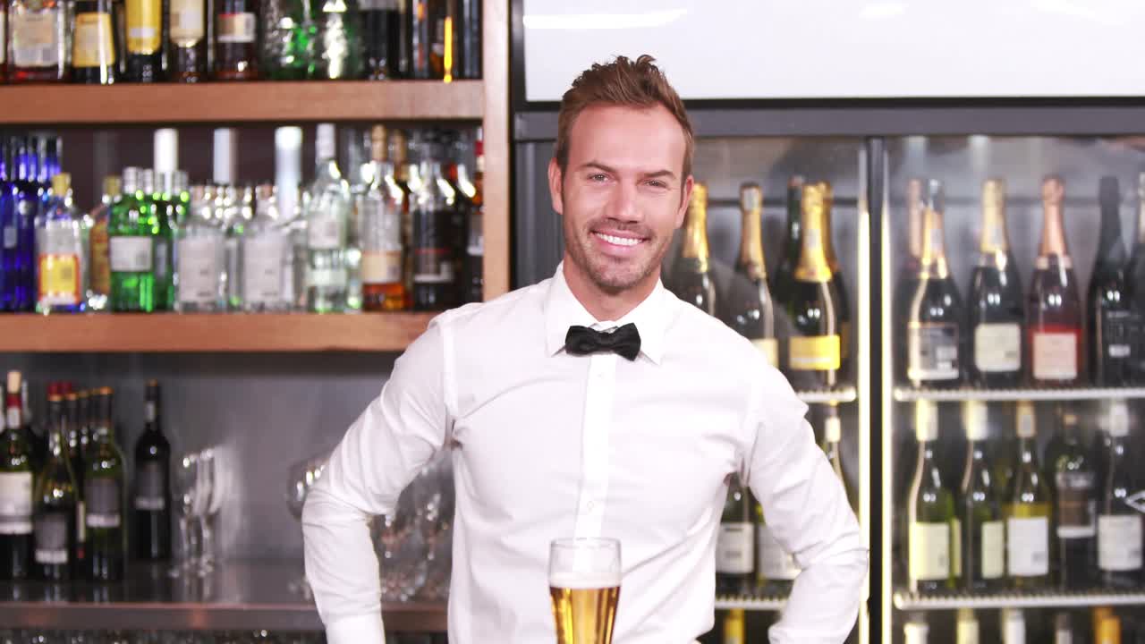 Barman sorridente che serve una birra