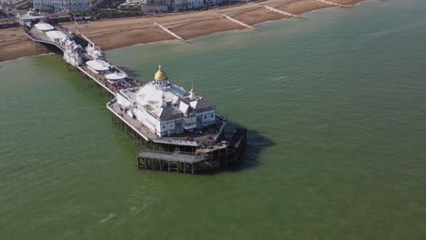 volando alrededor del muelle de eastbourne, frente al mar y la playa