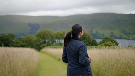 Slow-Motion-Young-Girl-Walking-on-Path-in-Middle-of-Field-and-Looking-Back-With-Smile