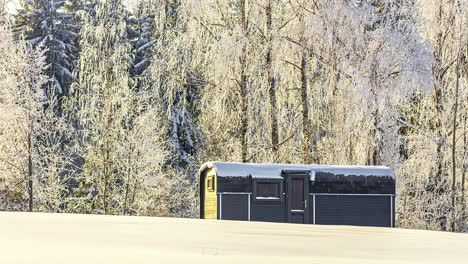 winter forest and modern sauna building, time lapse view