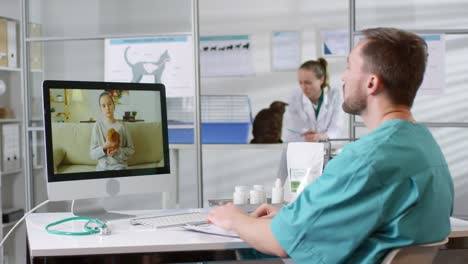 Male-Veterinarian-Giving-Online-Consultation-Via-Video-Call-And-Talking-To-A-Little-Girl-Holding-Her-Hamster