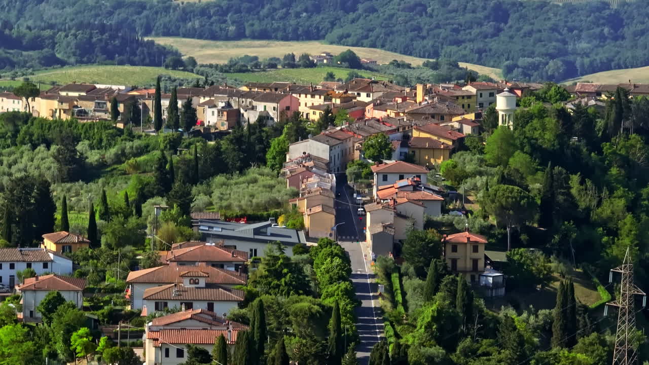 Telephoto drone shot tilting over the Marcialla town, sunny day in Tuscany, Italy