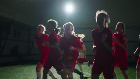 girls soccer team running and smiling during indoor practice