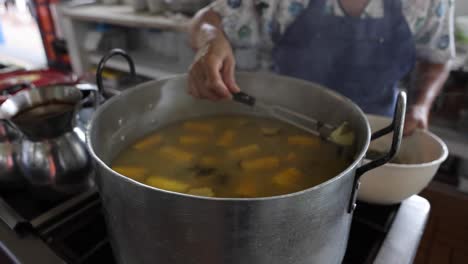 female chef serving hot sancocho soup