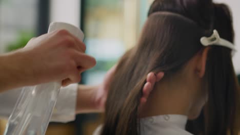 미용 제품으로 머리카락을 스프레이하는 미용사의  ⁇ 드 헬드 뷰
