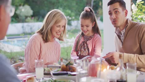 Vídeo-De-Feliz-Padre,-Hija-Y-Abuelos-Caucásicos-Hablando-En-Una-Mesa-Al-Aire-Libre