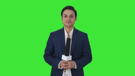 portrait of happy indian reporter green screen