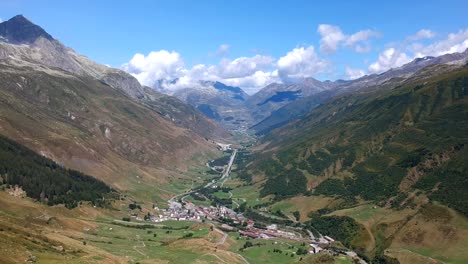 Toma-Panorámica-De-Drones,-Mirando-Hacia-Abajo-Desde-El-Paso-De-Furka-Hacia-El-Valle-Alpino-Y-La-Ciudad-De-Realp