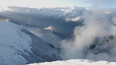 Breath-taking-overview-of-a-snowy-scene-in-New-Zealand's-National-Park-in-Fiordland-with-the-glacier-carved-valleys-and-the-river-on-the-background