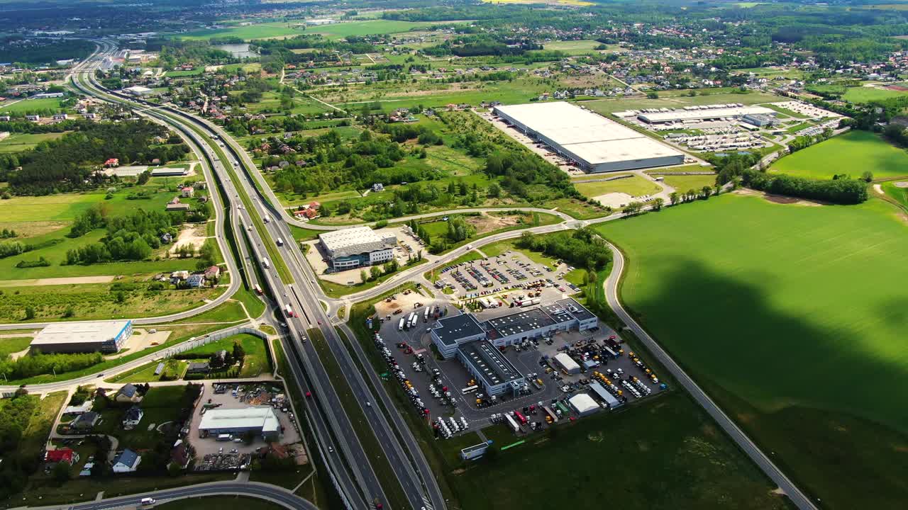 edificios del centro logístico, almacenes cerca de la autopista, vista desde la altura, un gran número de camiones en el estacionamiento cerca del almacén