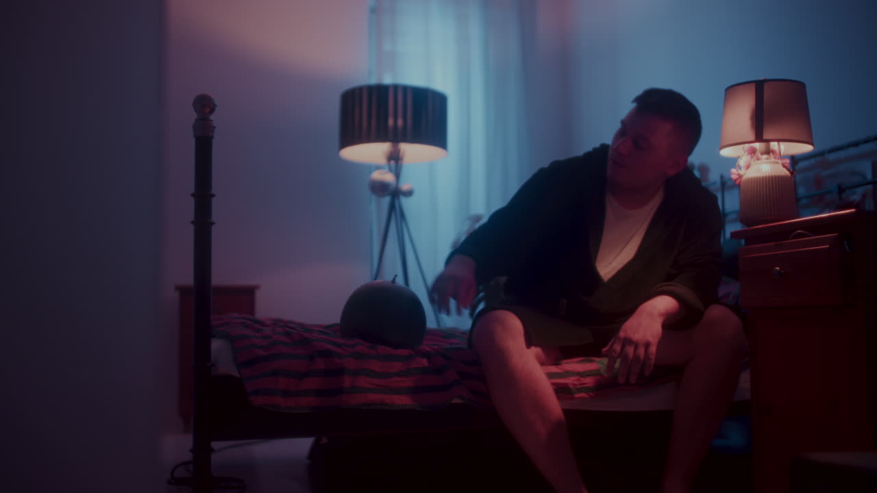 Uomo seduto in una camera da letto di notte