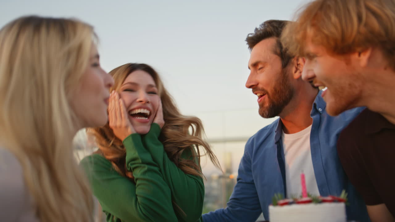 즐거운 친구들과 함께 생일을 축하하는 흥분된 여성이 야외에서 가까이 다가옵니다.