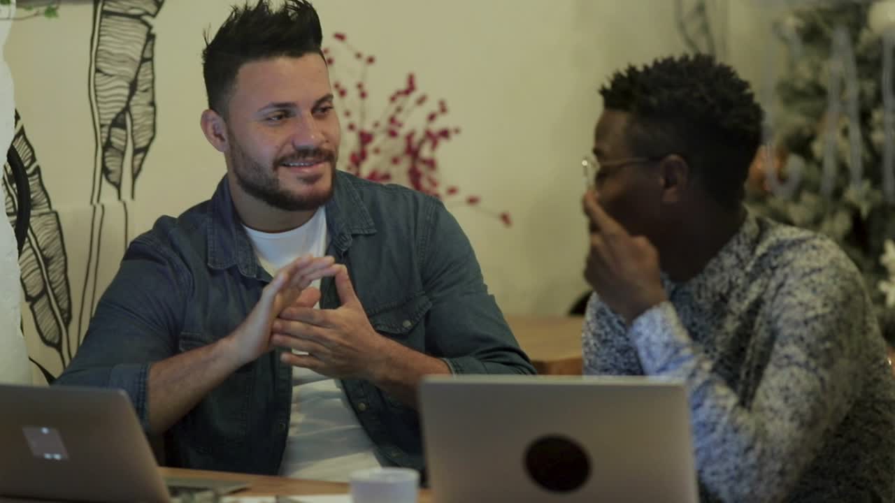 trabajadores independientes alegres discutiendo el trabajo en una cafetería