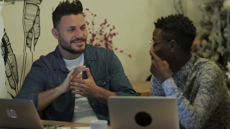 Cheerful freelancers discussing work in coffee shop