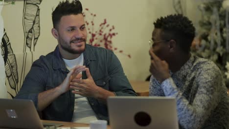 Cheerful-freelancers-discussing-work-in-coffee-shop