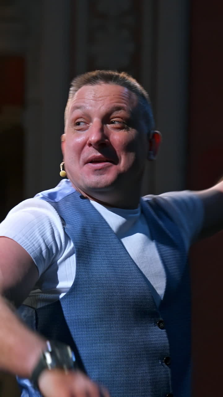 Actor on classic theater stage. Man is speaking in spotlights during the performance. Side view video. Vertical video