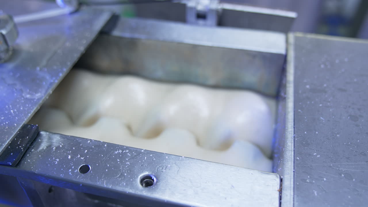 White liquid substance being mixed in a special tank. Milky stuff being mixed and whipped by nozzles in automatic machine. Confectionary production concept.