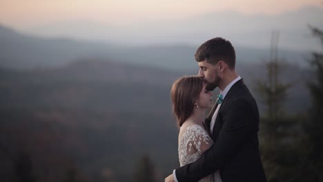 Recién-Casados.-Novio-Caucásico-Con-Novia-En-La-Ladera-De-La-Montaña.-Pareja-De-Novios.-Felices