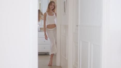 young alluring lady walking in hall of apartment