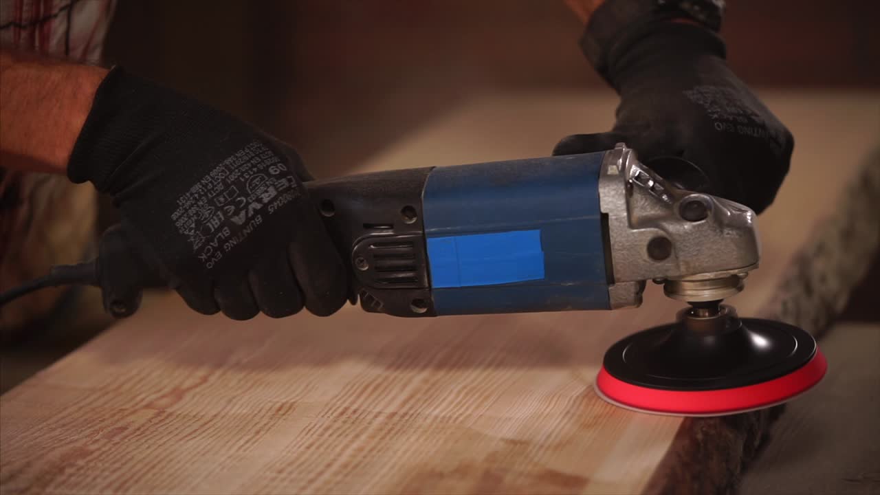 trabajo de la madera: acabado de una tabla de madera con una lijadora