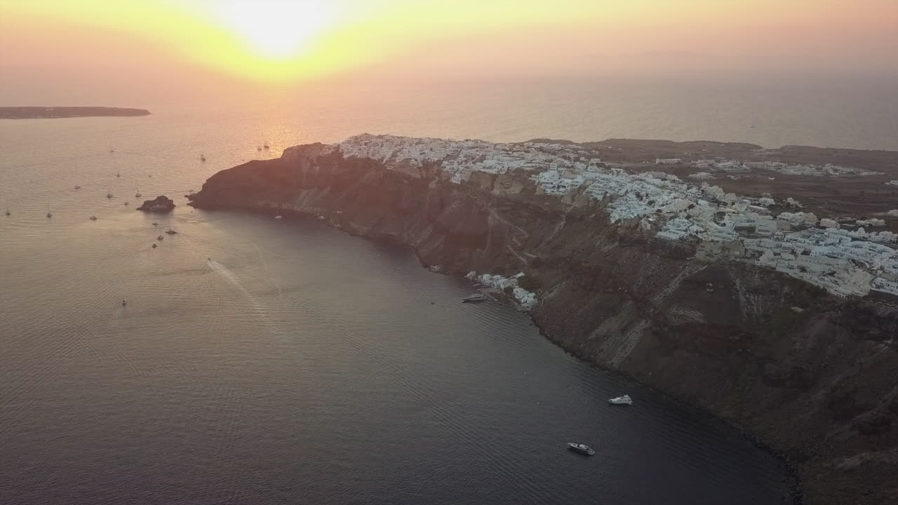 Golden sunset aerial of cliff top Oia on Greek island of Santorini
