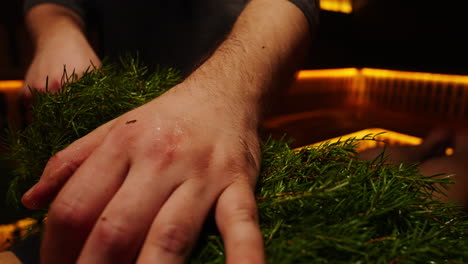 hands arranging evergreen wreath