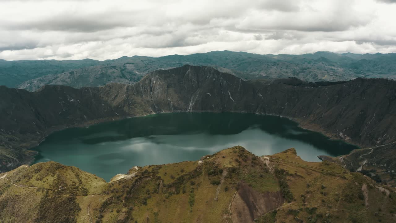 Veduta panoramica aerea che mostra un paesaggio vulcanico con un tranquillo lago blu nel cratere nelle Ande.