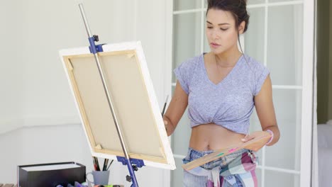 serious young female artist painting outdoors