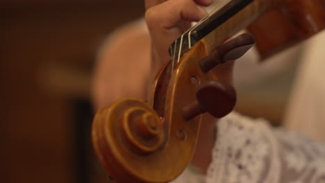 Close-Up-of-Violin-Peg-with-Musician's-Bow-Performance-in-a-Studio-Setting