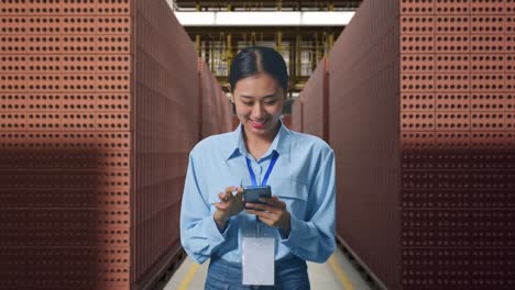 woman using phone in a brick warehouse