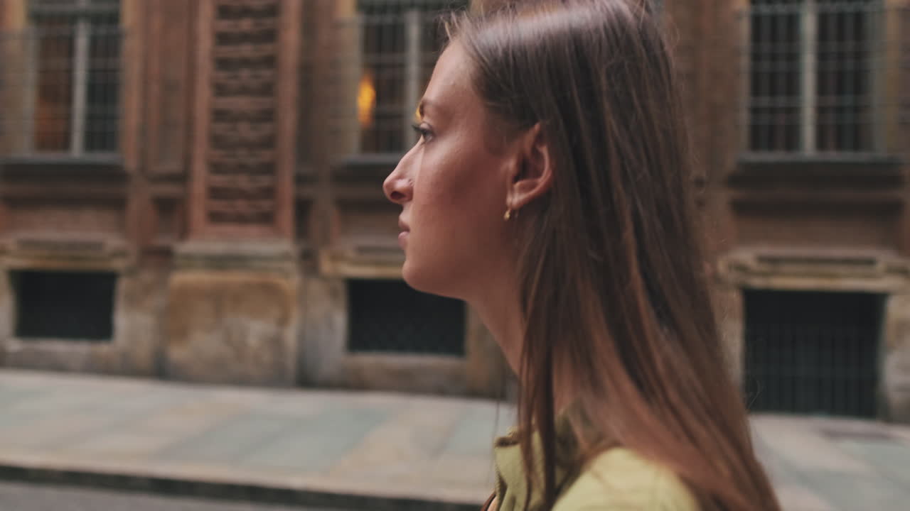Joven caminando por una calle de la ciudad, de perfil