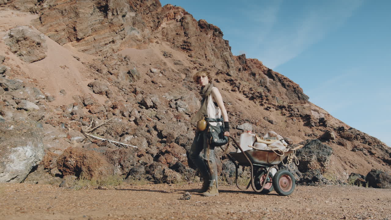 mujer caminando con un carro en un mundo post-apocalíptico