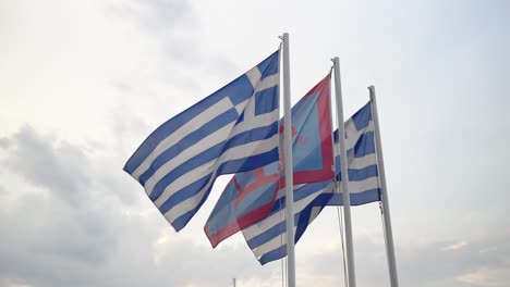 Flagge-Der-Griechischen-Insel-Spetses-Zwischen-Zwei-Griechischen-Nationalflaggen,-Die-Langsam-Im-Wind-Wehen,-Mit-Himmel-Und-Wolken-Im-Hintergrund
