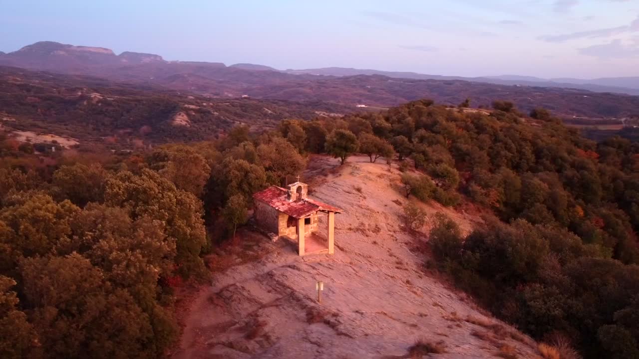 vista aérea de una capilla en la cima de una montaña en los pirineos al atardecer