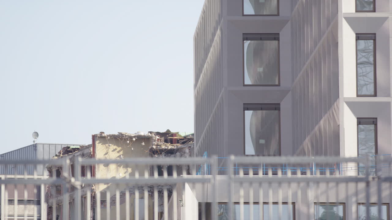 Contrast between a modern building and a demolished structure