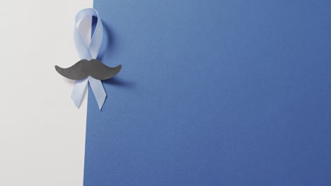 video de bigote de papel y cinta azul pálido de cáncer de próstata sobre fondo blanco y azul