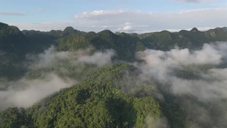 drone moves toward the cloudy green jungle and mountain top