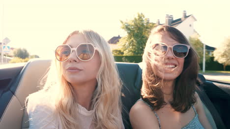 two women enjoying a road trip in a convertible