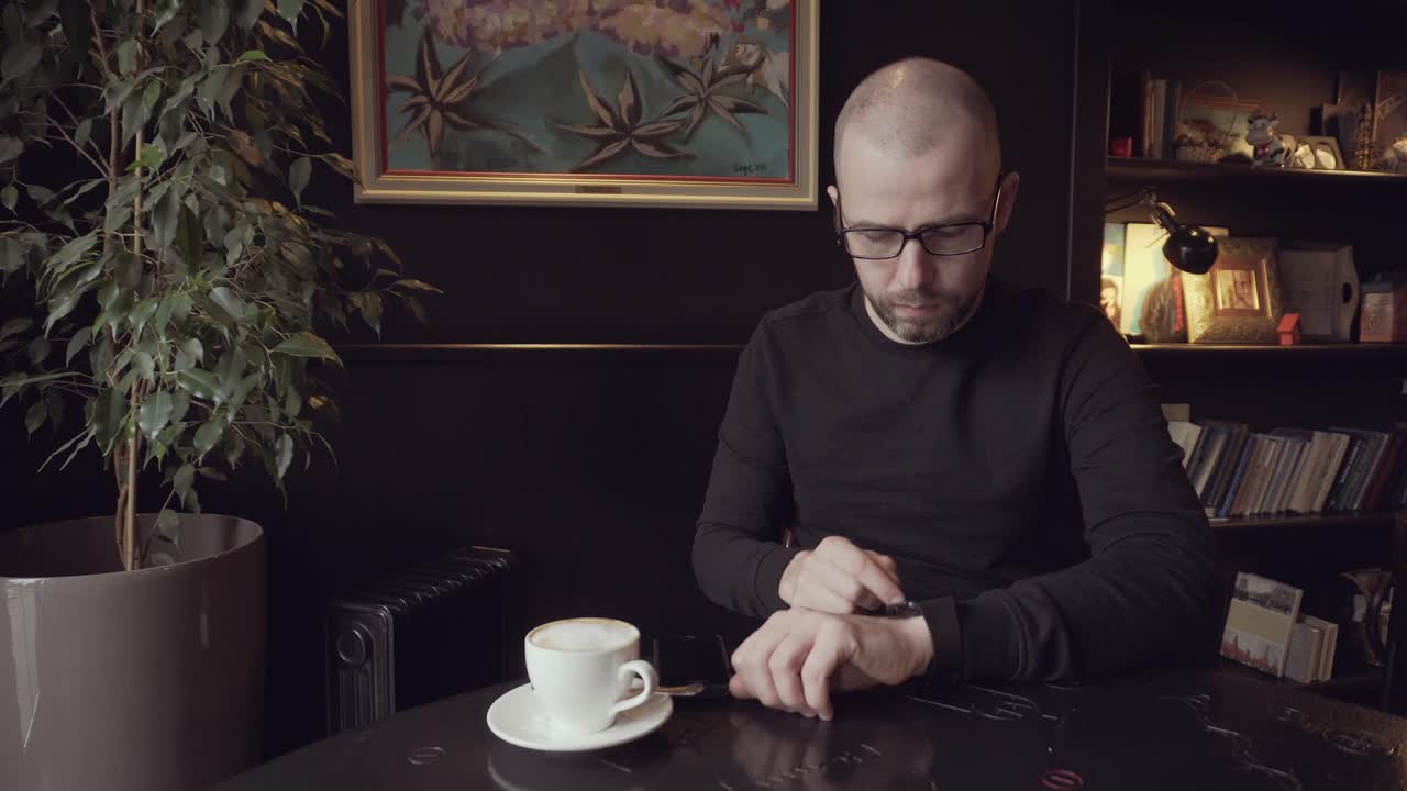 Man Checking Time in a Cafe