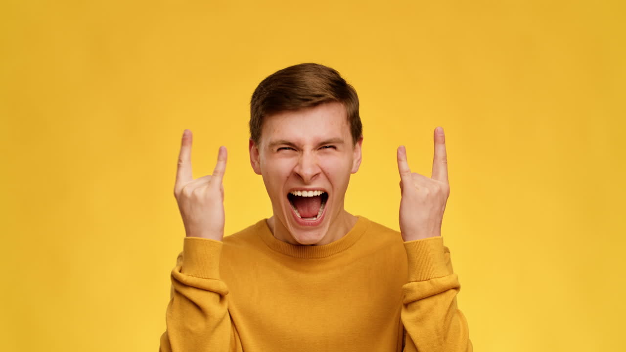 Excited Young Man Making Rock Gesture