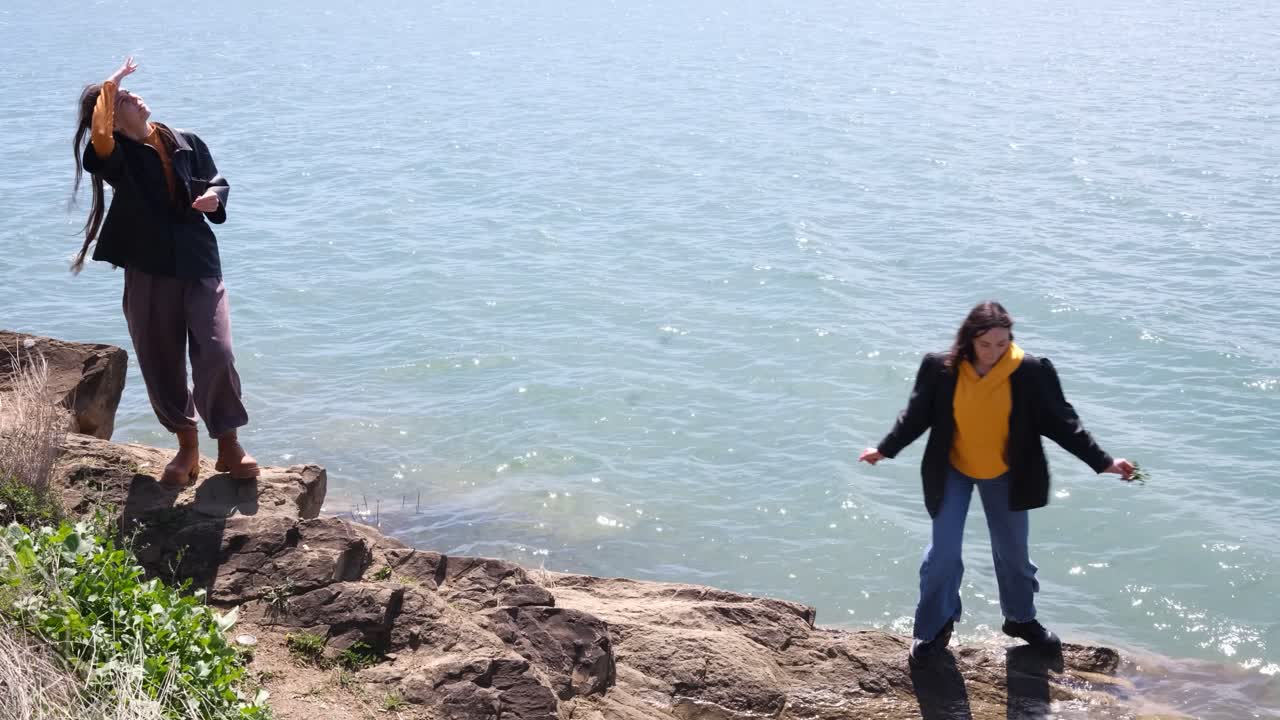 Two women on rocks by the sea