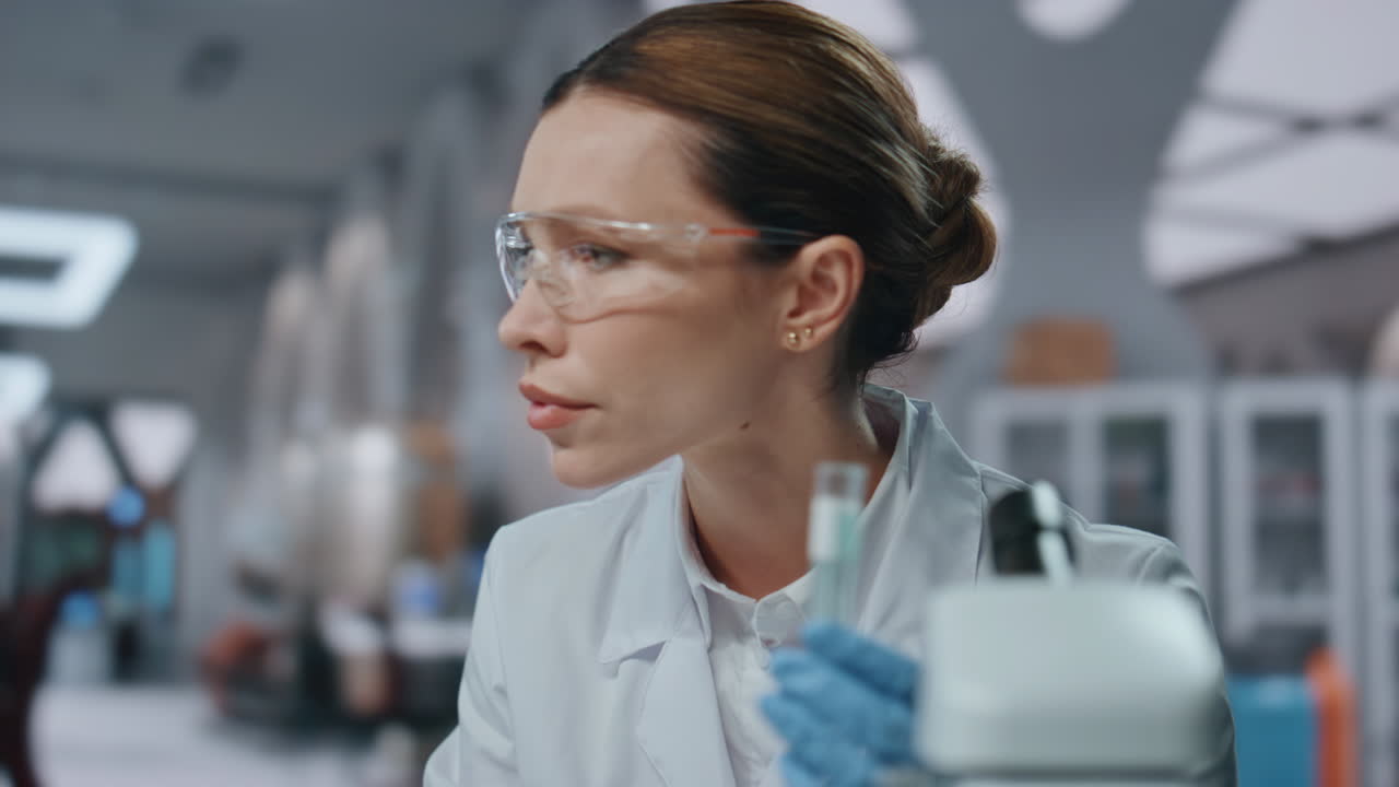 Biotechnological researcher typing computer developing vaccine in lab close up.