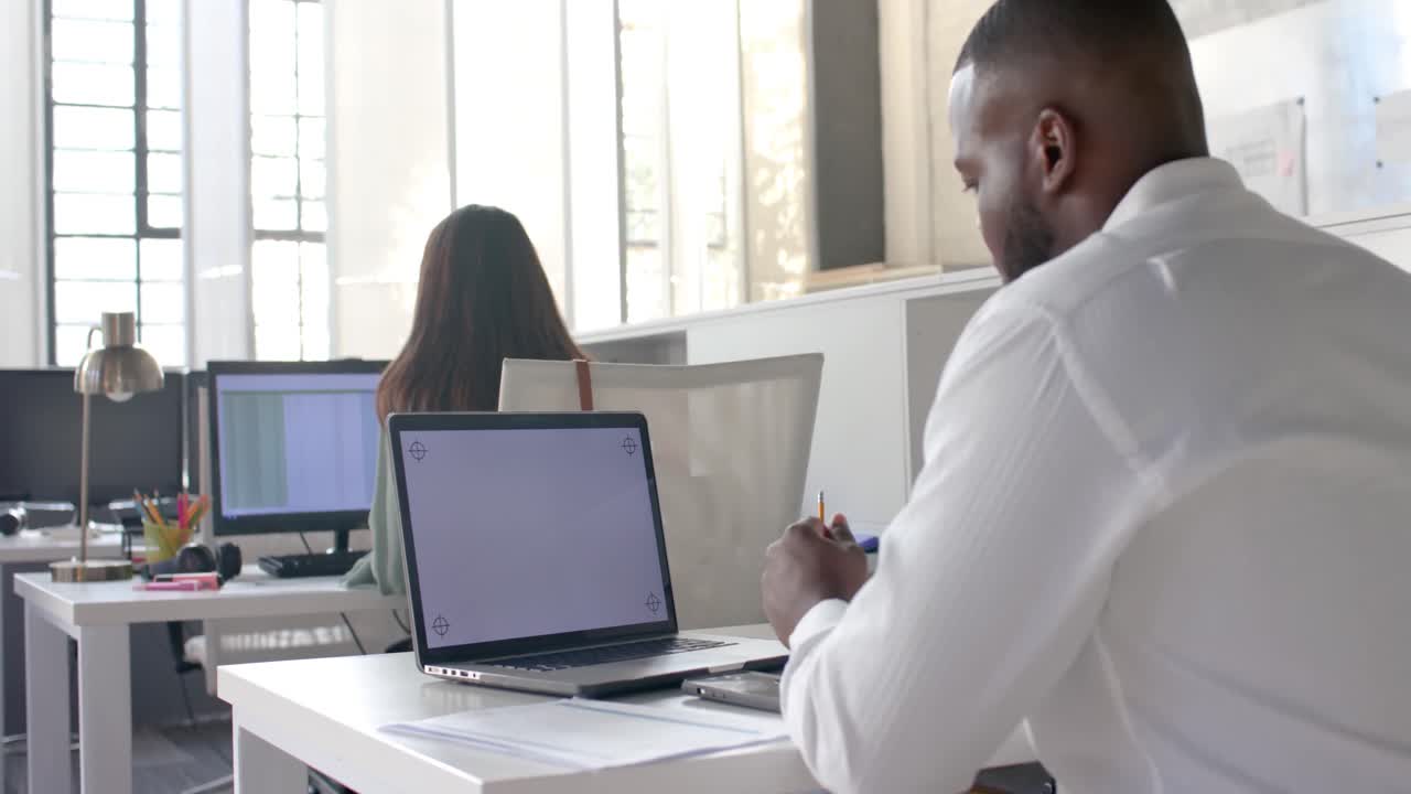 hombre de negocios afroamericano casual teniendo una llamada de video portátil con espacio de copia en la pantalla, cámara lenta