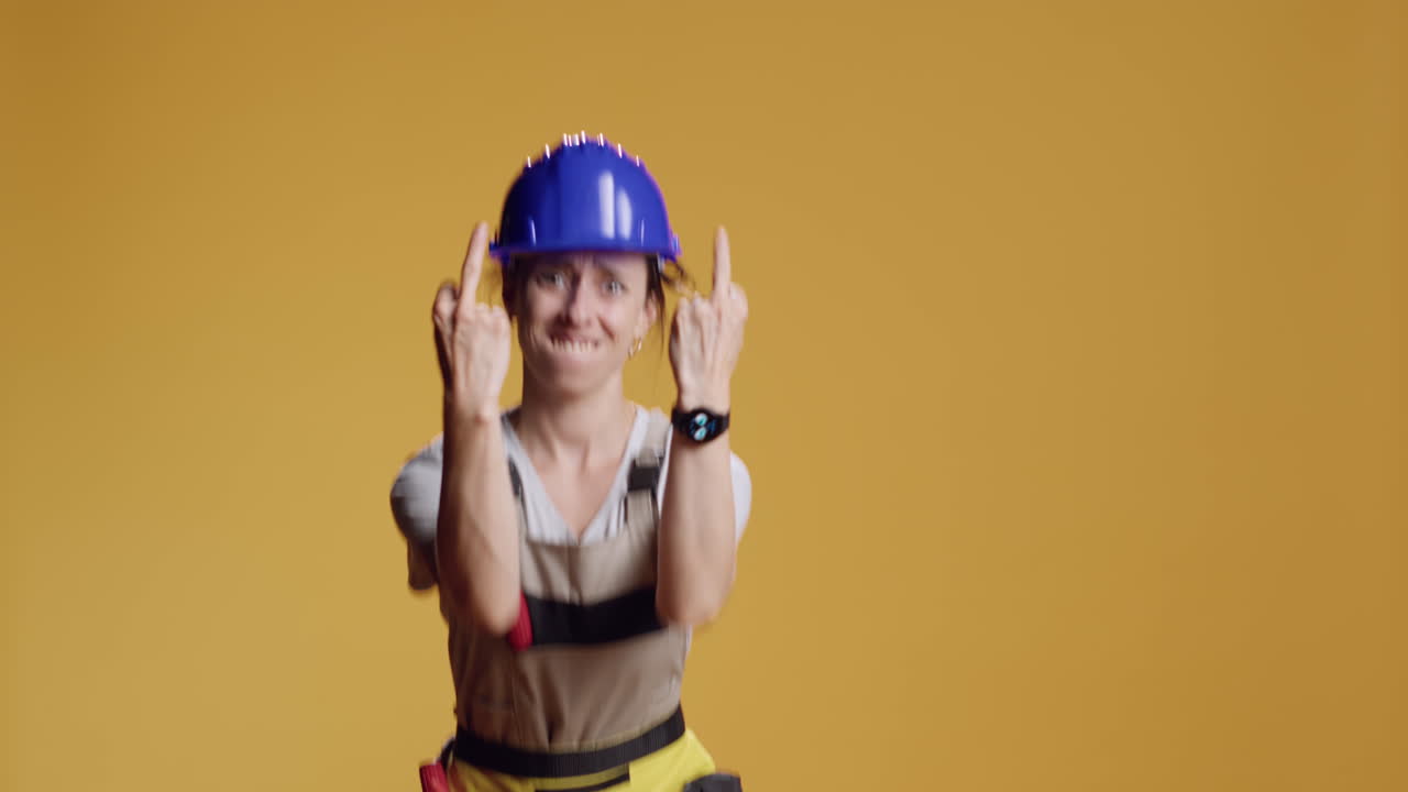 Portrait of rude handywoman giving middle finger on camera