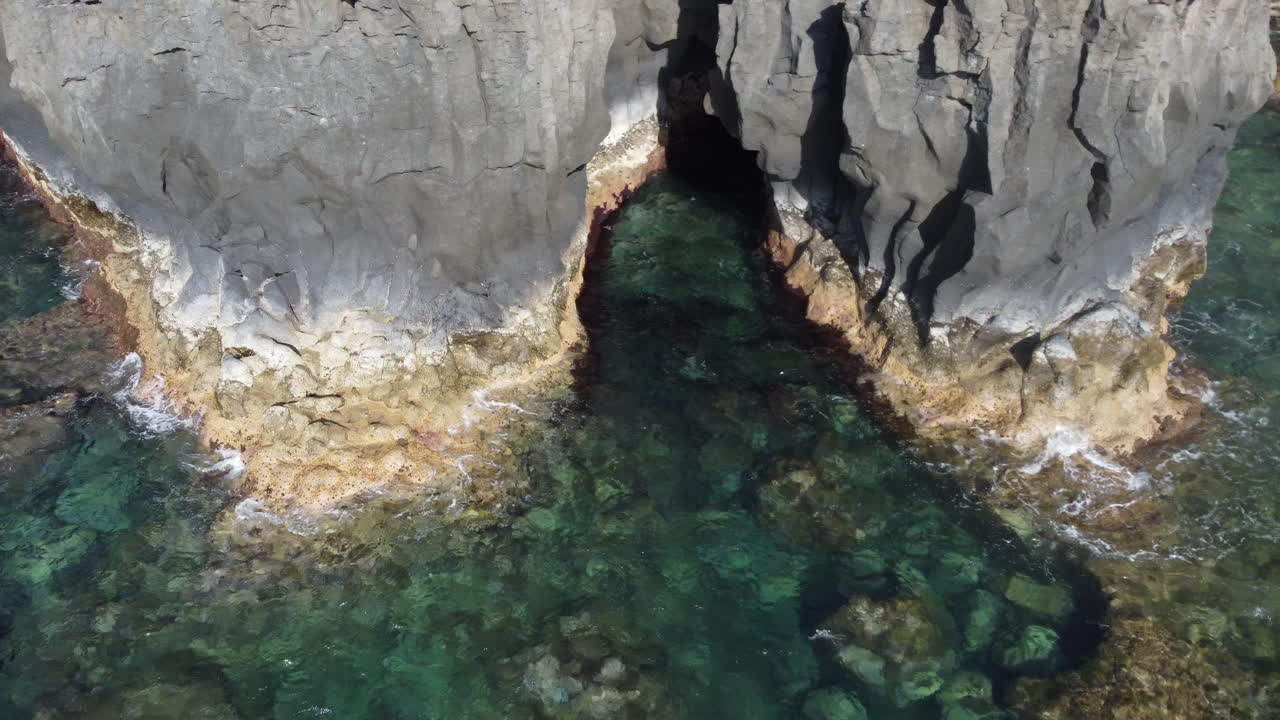 acantilados rocosos en los que las olas de agua de mar turquesa azul claro salpican, isla canaria, hierro - disparo de drones