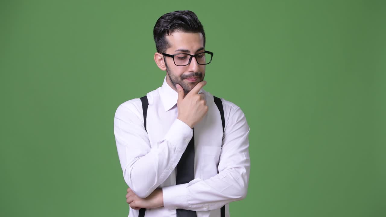 joven empresario persa barbudo y guapo contra un fondo verde