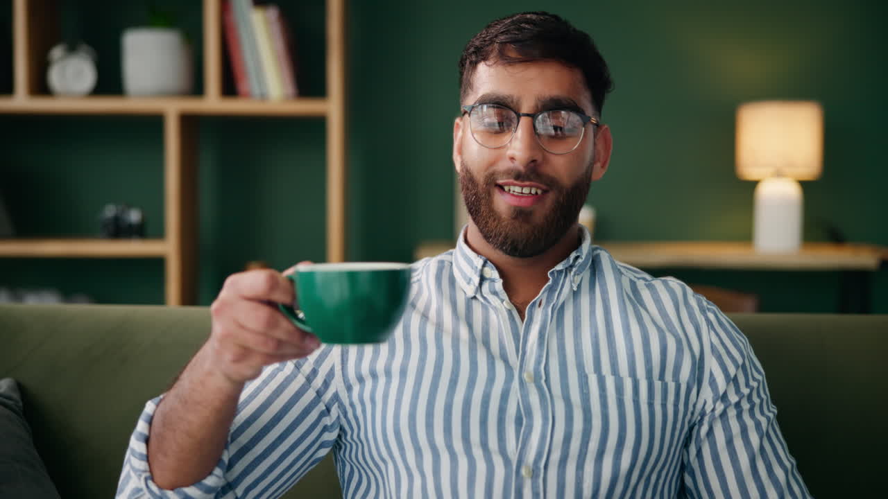 Man drinking coffee while working on laptop