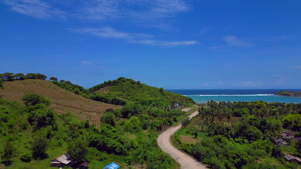 Tropischer Resortkomplex mit einzigartiger Architektur, Infinity-Pool und üppig grünem Berghang auf der Insel Lombok, Indonesien. Beste Panorama-Luftaufnahme per Drohne mit Schwenk nach links