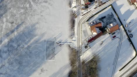 casa junto al lago congelado - gente patinando sobre hielo
